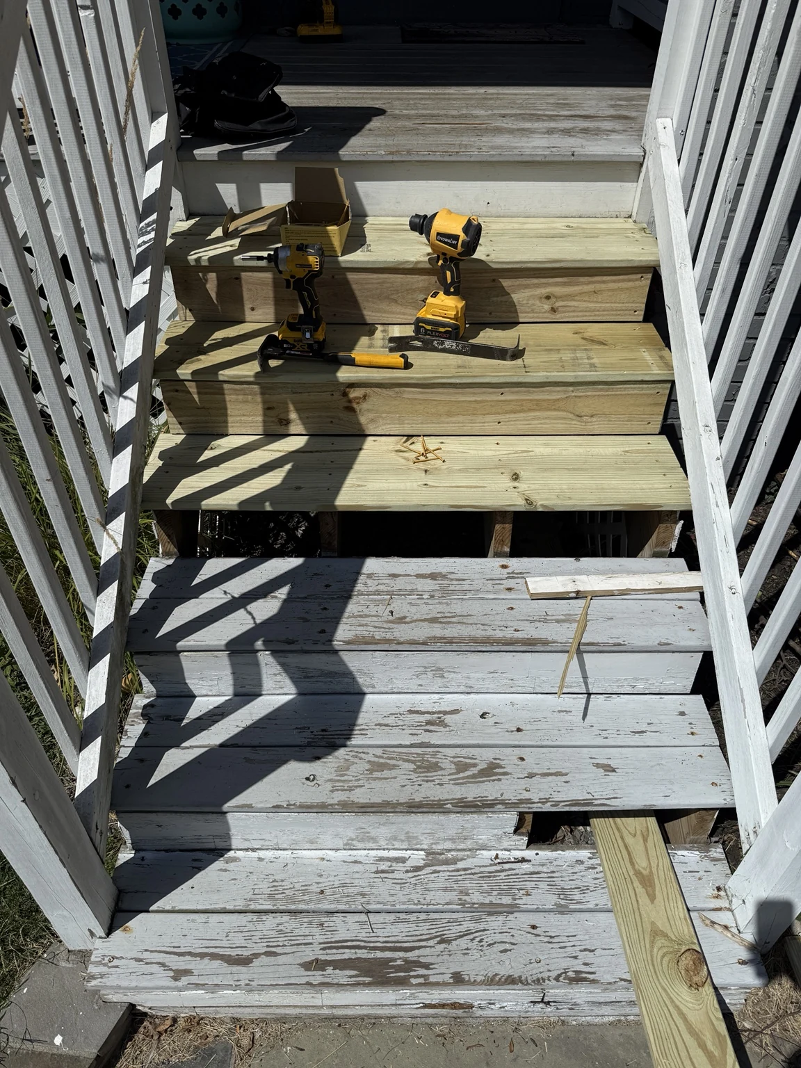 Exterior stair rebuild in progress with some old painted steps and some new pressure-treated steps