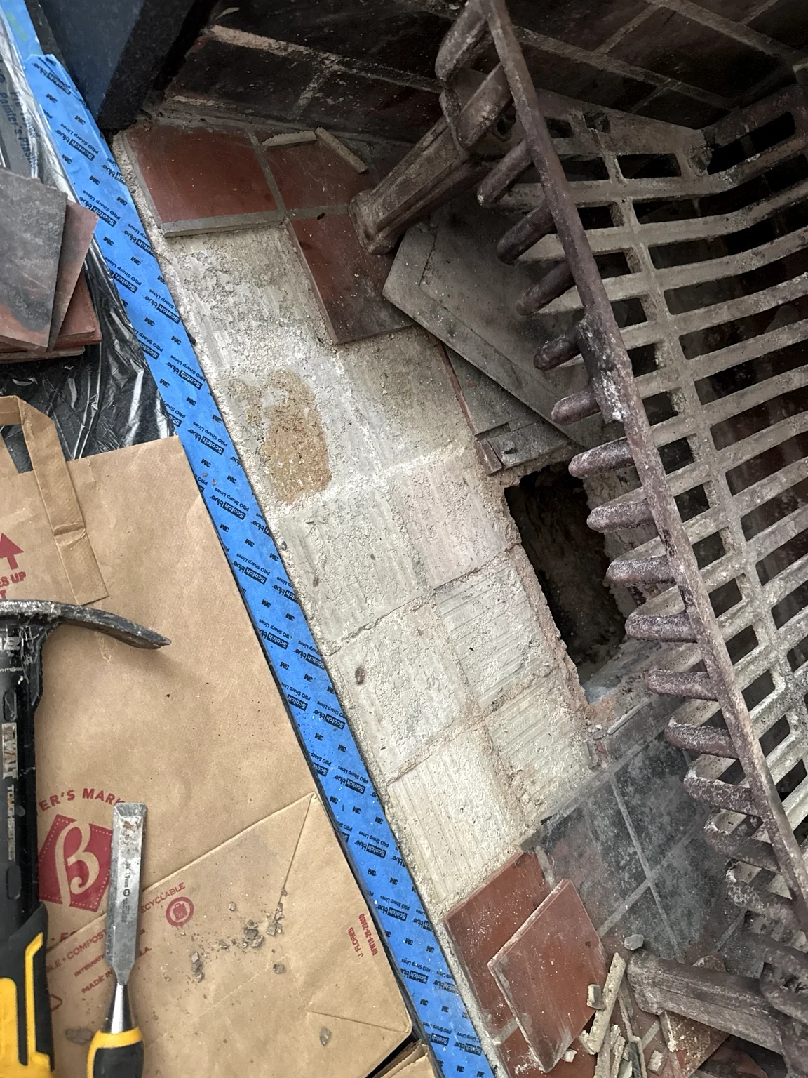 Damaged fireplace tile being selectively removed